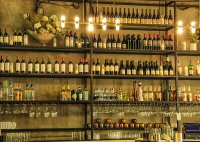 A stylish bar shelf filled with assorted wine and liquor bottles, elegantly arranged for a sophisticated ambiance.