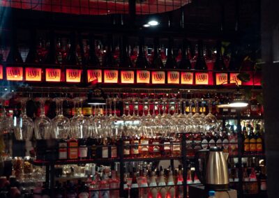 Stylish bar interior showcasing an array of hanging glassware and illuminated shelves.