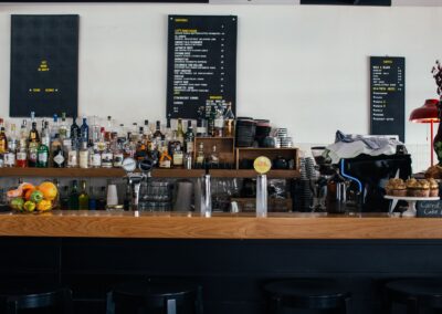 Contemporary cafe with wooden shelves full of many bottles and menu on wall